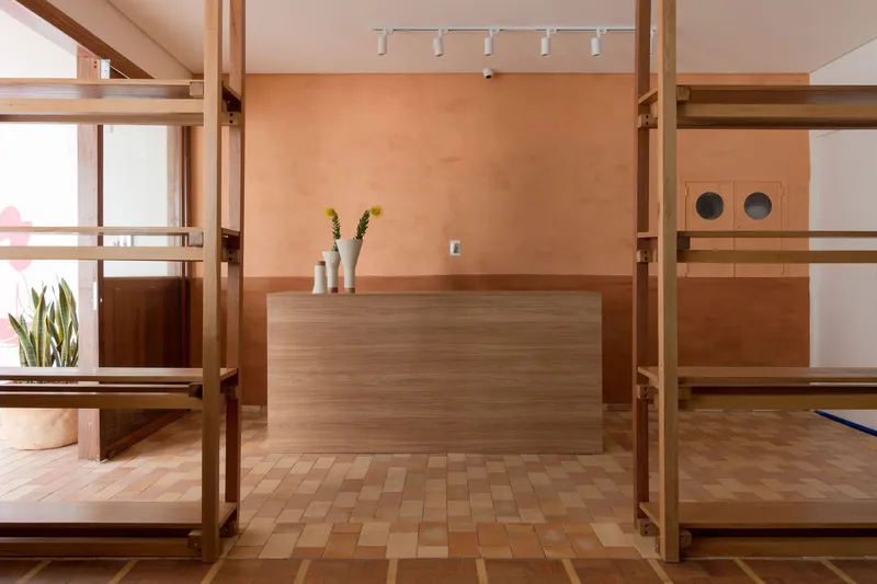 Interior reception area with timber shelving frame, parquet flooring, and peach-toned plaster wall