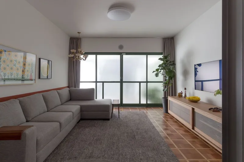 Living room with grey sectional sofa facing floor-to-ceiling frosted glass doors to a balcony