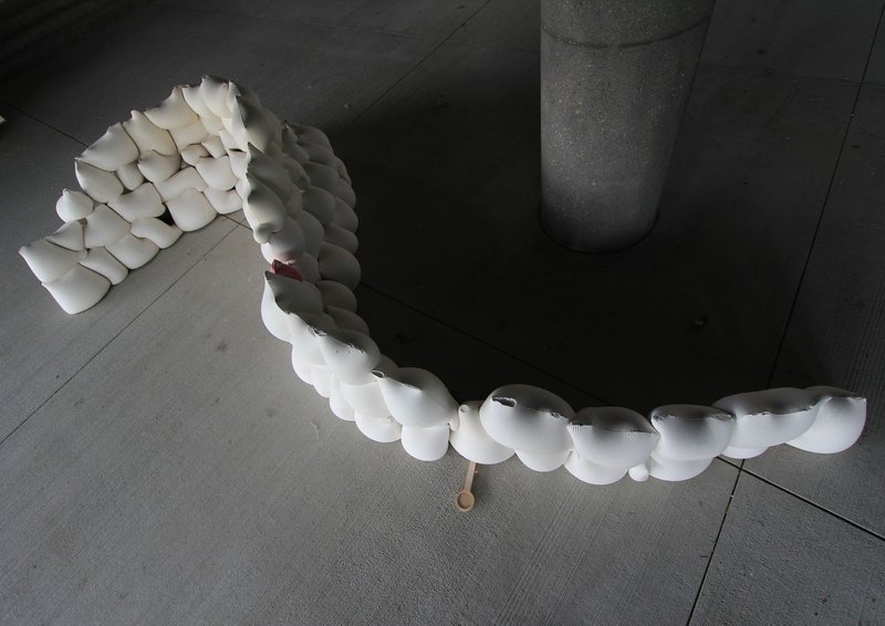 Overhead view of curved white inflatable seating bench with person lying across modules