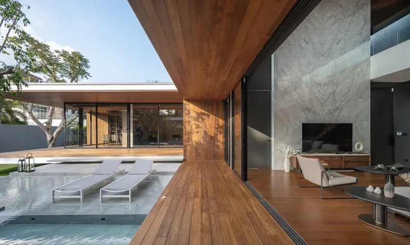 Timber deck extending from interior living space to pool terrace with cantilevered wood soffit overhead