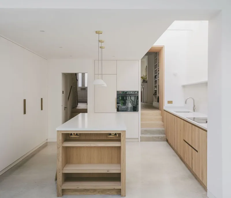 Kitchen with oak island and white cabinetry beneath a recessed skylight