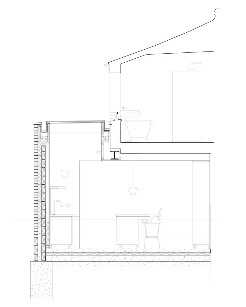 Section drawing showing bathroom above kitchen with timber joists and sloped drainage pipe detail