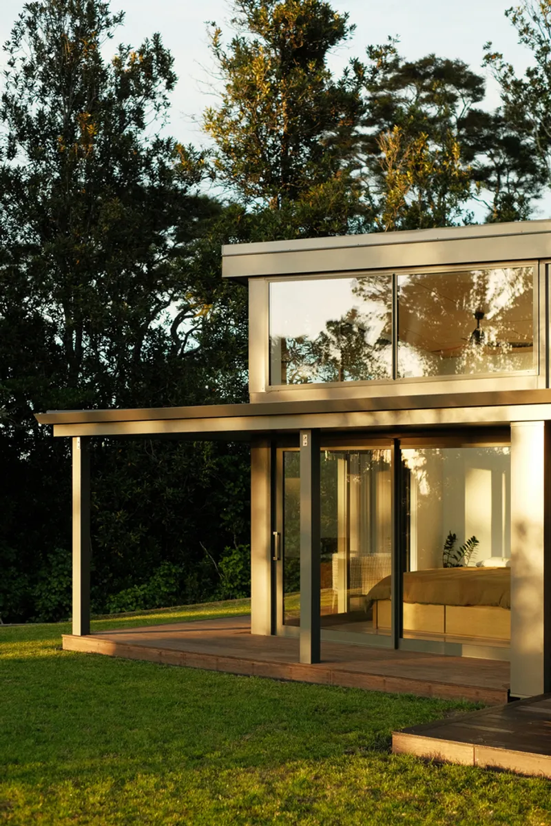 Two-storey volume with open terrace below and bedroom above framed by floor-to-ceiling glazing