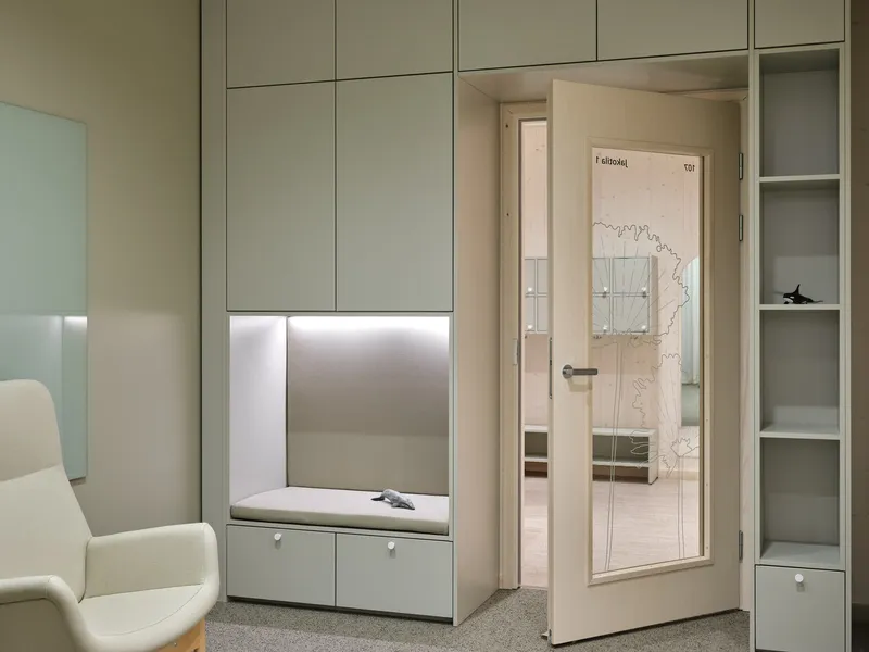 Built-in storage unit with illuminated alcove and glazed door leading to adjoining room
