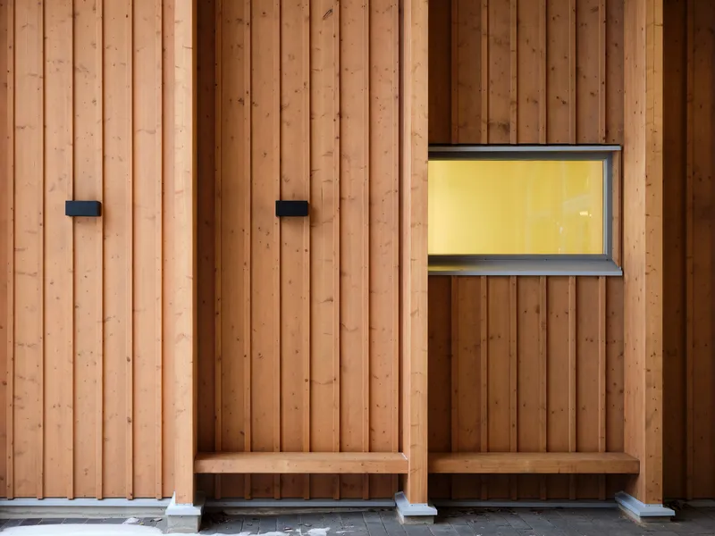 Timber wall with two built-in benches, black metal fixtures, and a horizontal window with yellow curtain