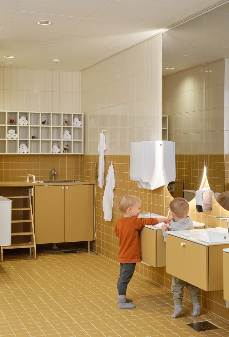 Bathroom with mustard-yellow tile walls, floating vanity, and two children at the sinks