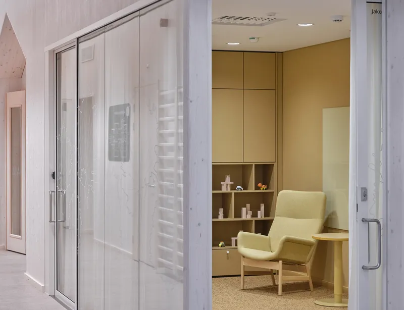 Glass sliding door with translucent panels opening to a consultation room with built-in shelving
