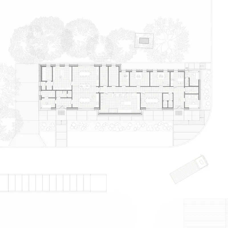 Floor plan drawing showing a linear arrangement of rooms flanking a central communal space with planted surroundings