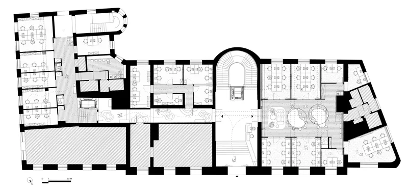 Floor plan drawing showing treatment rooms, curved staircase, and rounded seating areas in an irregular footprint