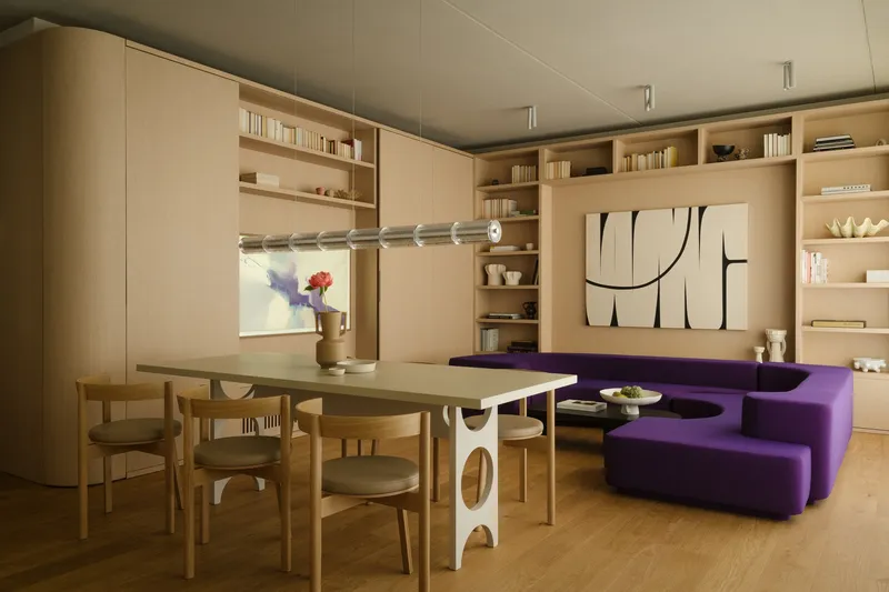 Open-plan living space with plywood millwork wrapping the perimeter and purple modular seating