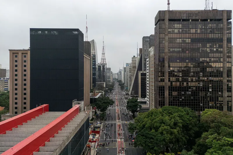 Red diagonal staircase leading from rooftop to the glass bridge with the boulevard stretching into the distance