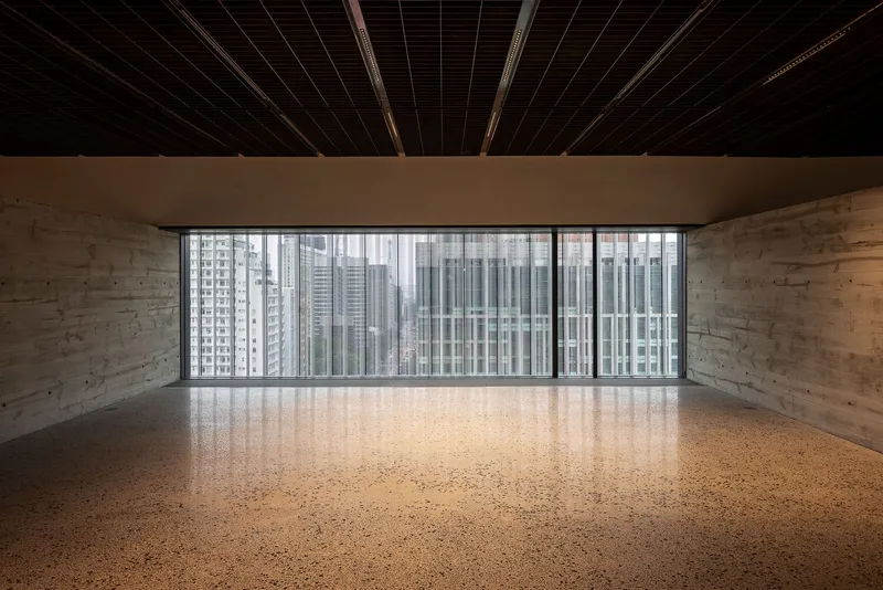 Polished terrazzo floor facing floor-to-ceiling glazing with views of neighboring high-rise buildings