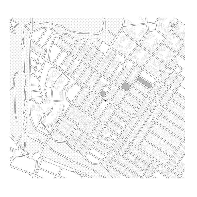 Site plan drawing showing the building footprint within a gridded urban block near a waterfront