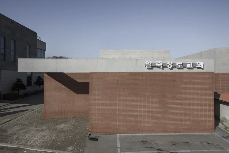 Entry view showing the red brick base topped by concrete walls with signage