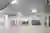This architectural image showcases the interior of a large, modern warehouse. The space is character