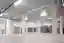 This architectural image showcases the interior of a large, modern warehouse. The space is character