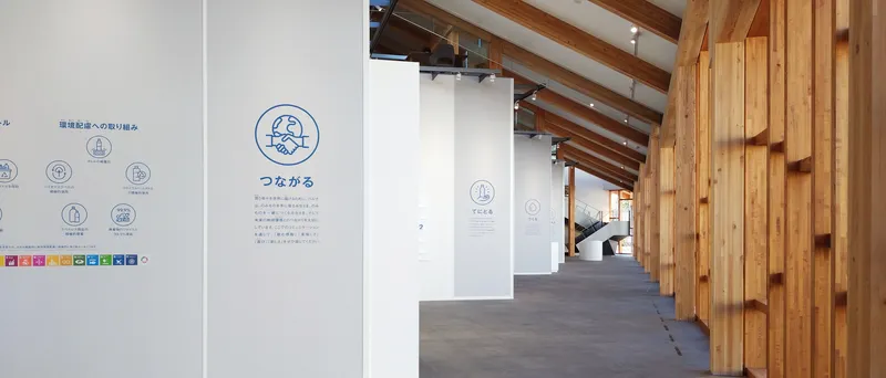 Corridor view showing informational wall graphics alongside timber cladding and exposed ceiling beams