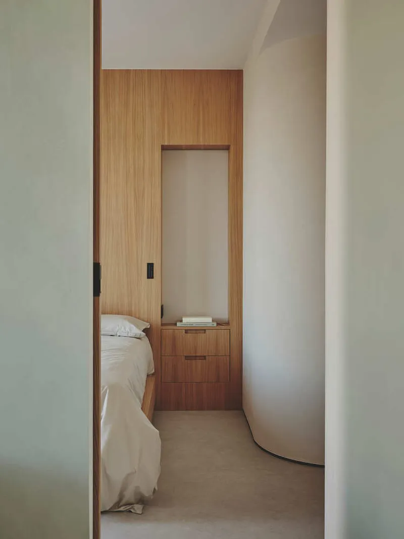 Narrow bedroom hallway with timber sliding door and built-in niche above low storage drawers