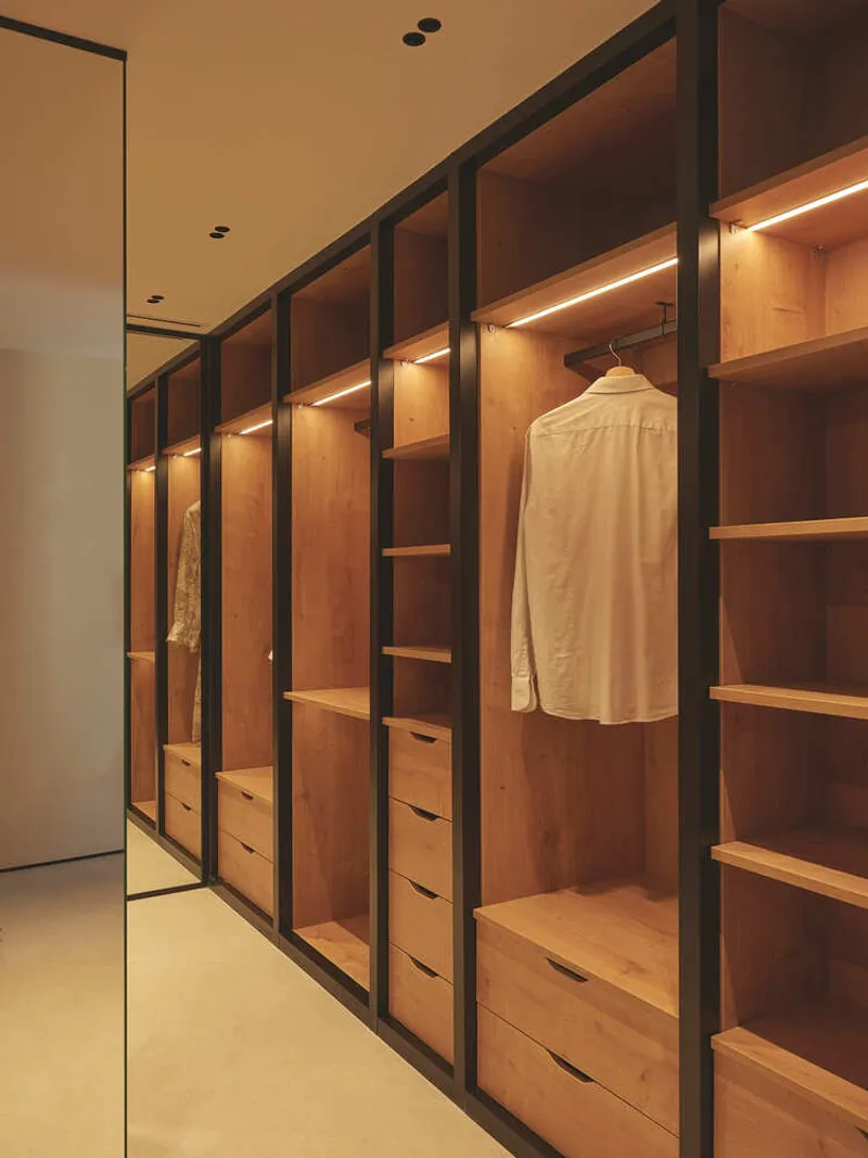 Walk-in closet with black-framed oak shelving and integrated LED strip lighting