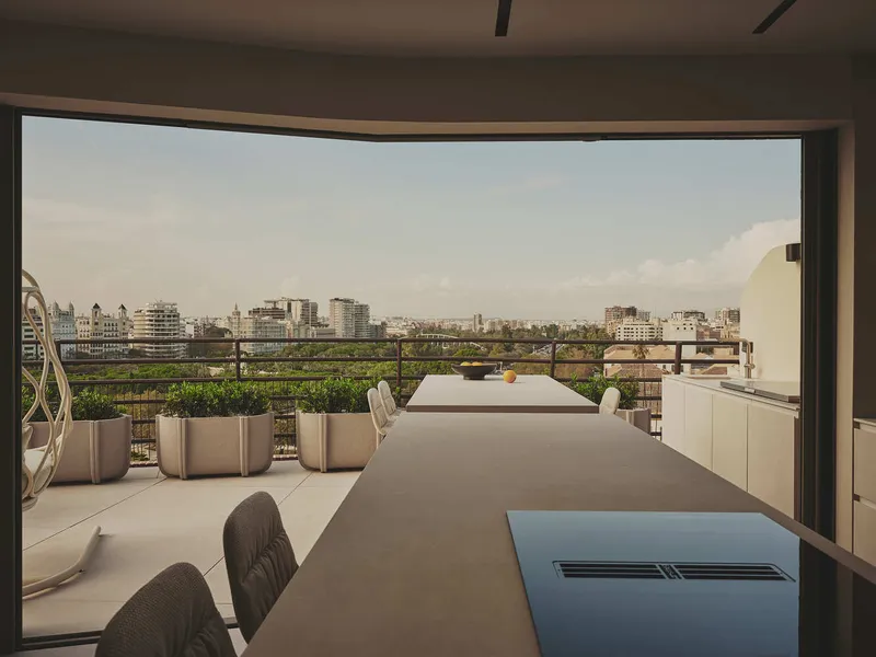 Rooftop terrace with dining table overlooking the cityscape at dusk
