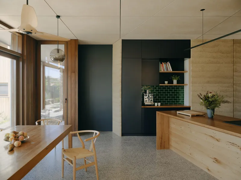 Open kitchen and dining area with timber table, plywood ceiling panels and green subway tile backsplash