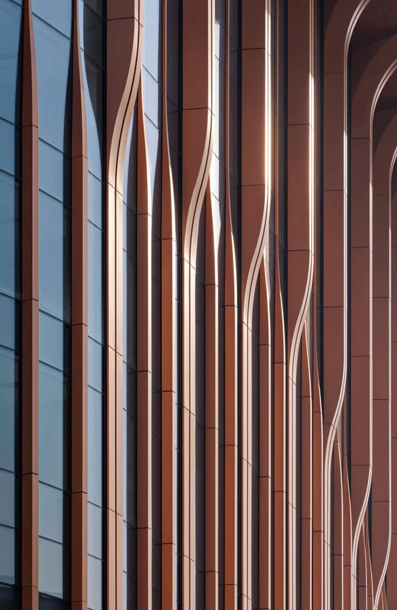 Facade detail showing vertical copper-toned panels and curved metal trim elements against clear sky