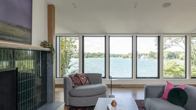 Living room with green-tiled fireplace and ribbon windows framing lake views