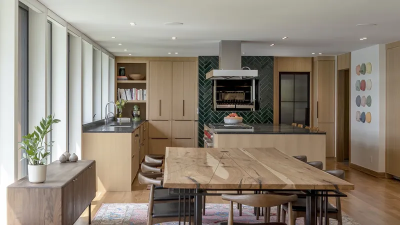 Kitchen island with veined wood top under green chevron-patterned tile accent wall