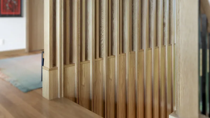 Detail of vertical timber slats with chamfered bases meeting the oak floor