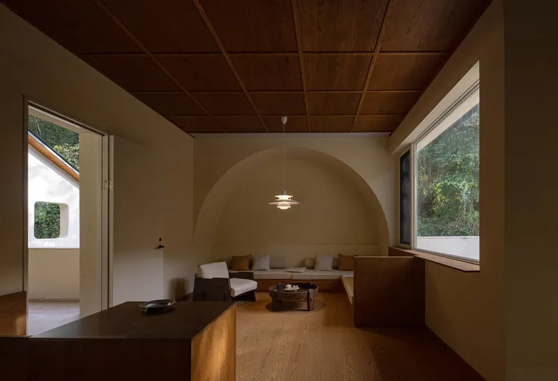 Living room with timber plank ceiling and arched wall recess framing a seating area