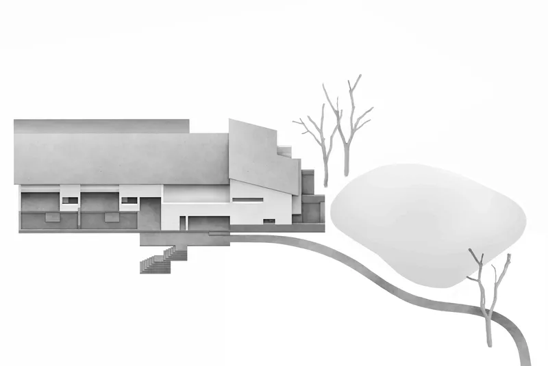 Physical model elevation showing horizontal volumes with recessed openings alongside curved pathway and bare trees