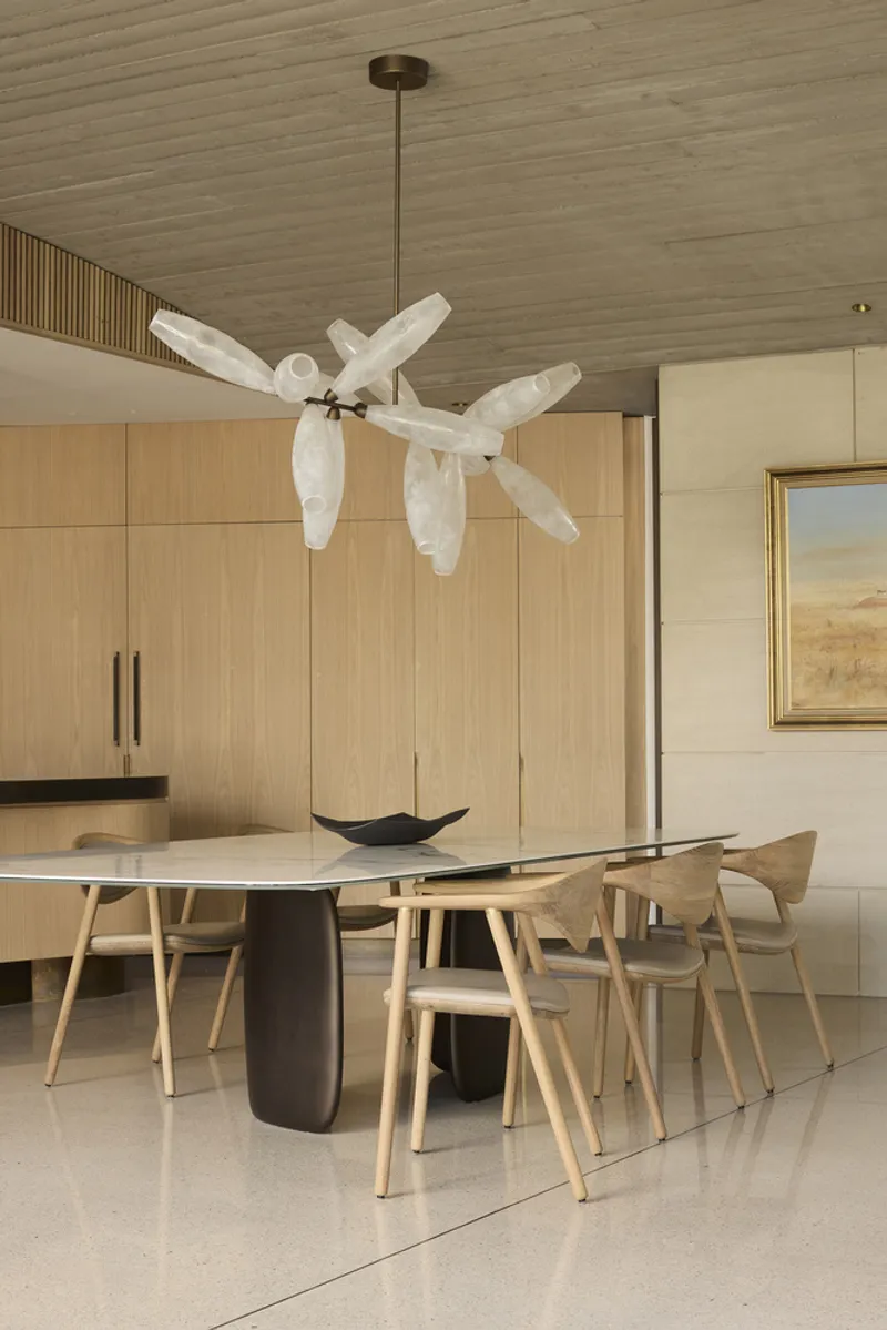 Dining area with white sculptural ceiling fan and timber-lined ceiling under soft natural light
