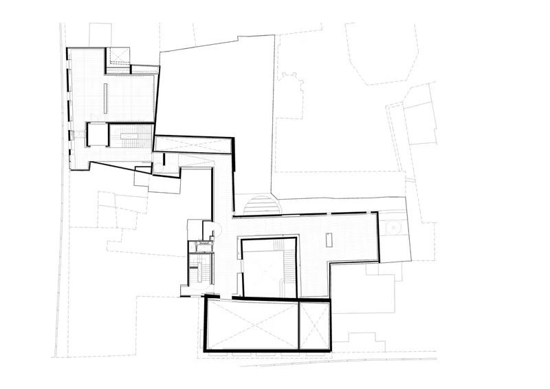 Floor plan drawing of split volumes connected by a glazed link with adjacent landscape areas