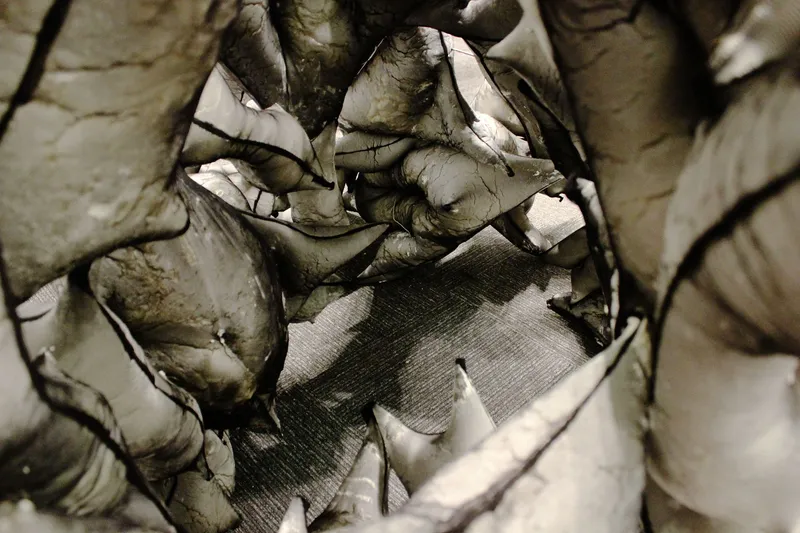 Close-up of deteriorated concrete cavity showing mesh reinforcement and fractured layers