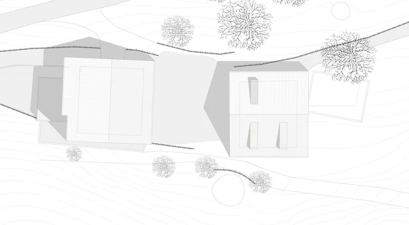 Site plan drawing showing an existing pitched-roof building and new rectilinear addition with trees