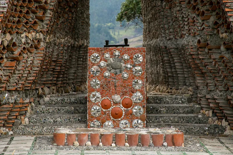 Decorative brick and ceramic tile panel framed by weathered stepped masonry piers