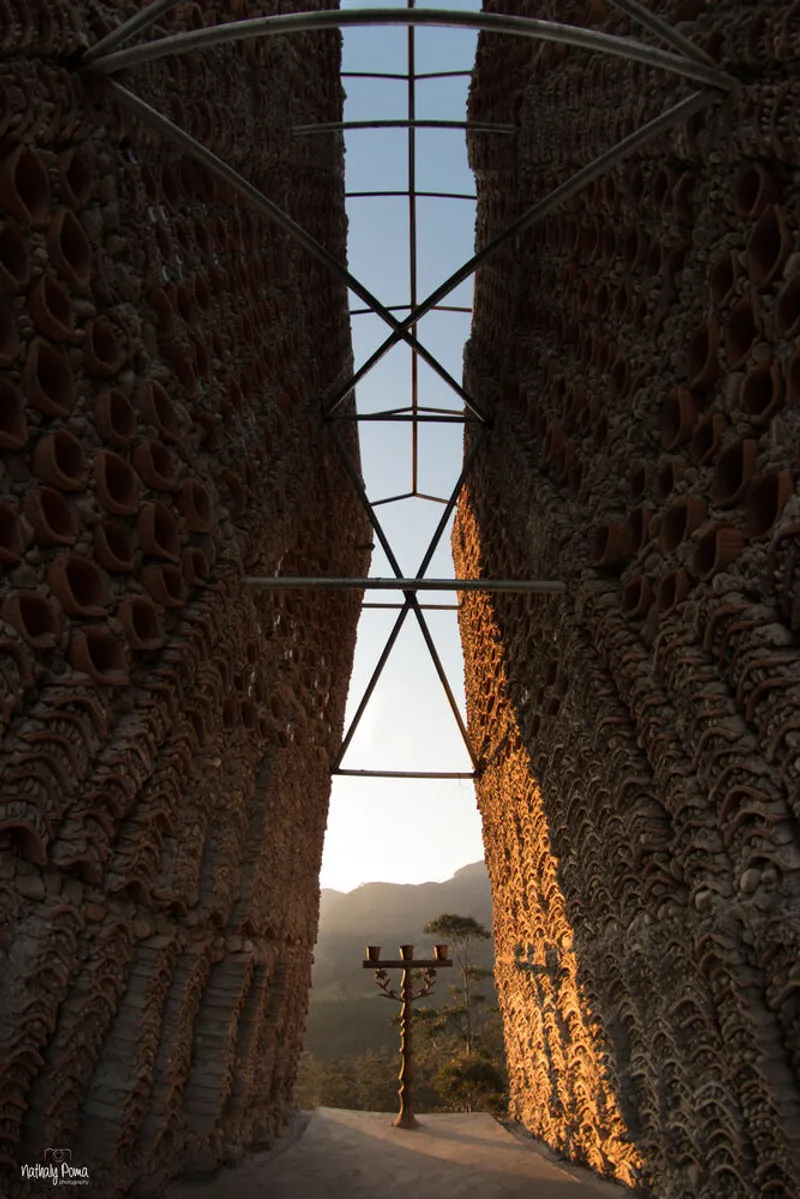Interior view up through textured brick walls with steel bracing and opening to sky