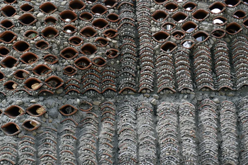 Close-up of patterned brickwork with overlapping terracotta tiles and stone infill