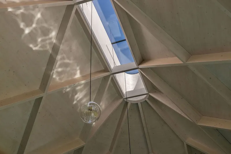 Upward view into the vaulted ceiling with skylight and glass pendant light