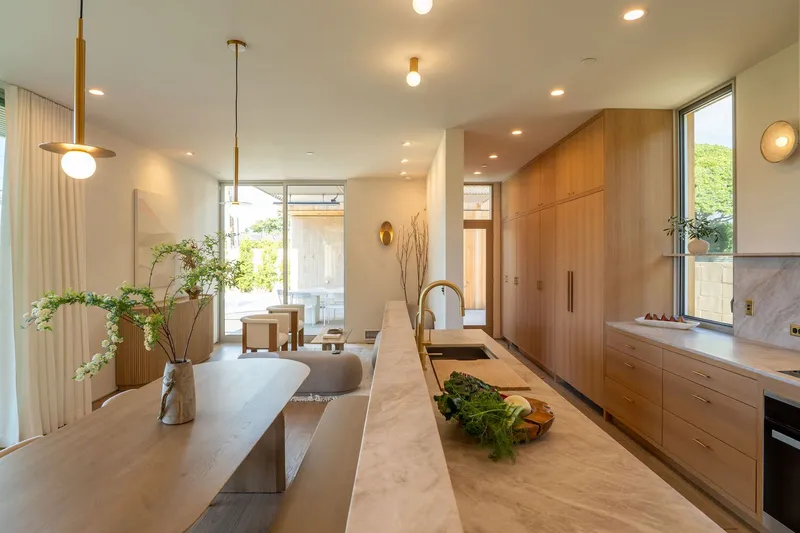Kitchen counter with stone surface looking through to living area and courtyard beyond