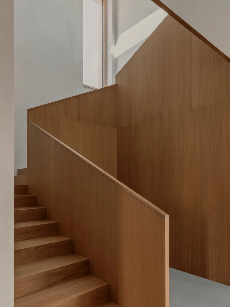 Detail of timber staircase showing clean joinery between treads and angled wall panels