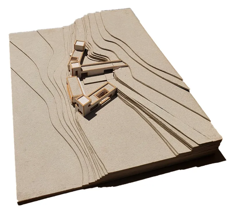 Physical model showing clustered volumes on contoured topography with pathways carved into the landscape