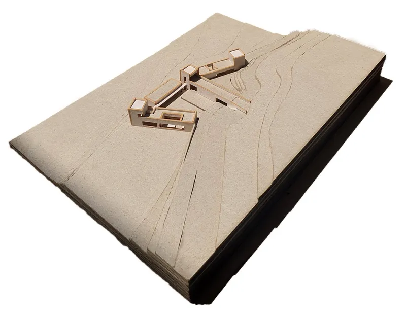 Overhead view of the site model with articulated building masses and carved topographic contour lines