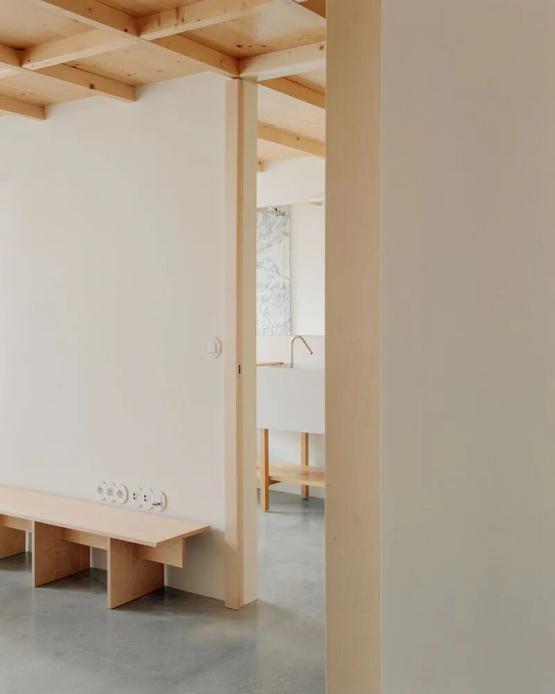 Interior doorway framed by plywood column with polished concrete floor and exposed ceiling structure