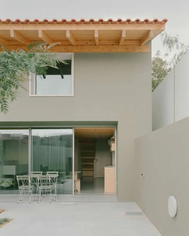 Rear courtyard with sliding glass doors, exposed timber eaves and overhanging tree branches