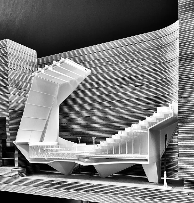 Physical model photograph of the angular auditorium volume within horizontal stratified masonry layers at night