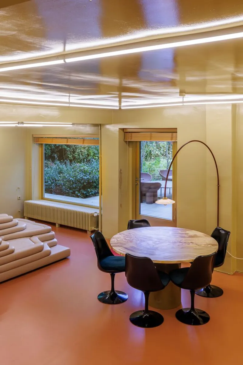 Interior dining area with orange resin floor and linear ceiling lights creating motion blur