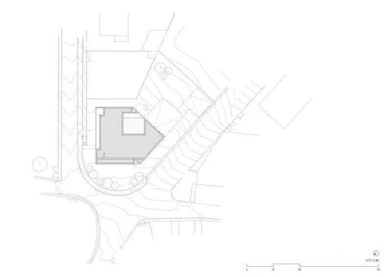Site plan drawing showing the wedge-shaped footprint between angled streets and parking areas