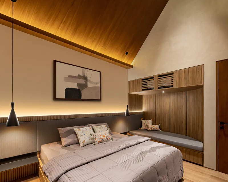 Bedroom showing timber built-in headboard, pendant lights and vaulted ceiling with concealed lighting