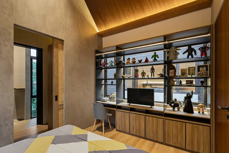 Study area with timber and metal display shelves holding collectibles beneath a sloped wooden ceiling